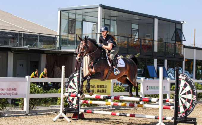 Mia riding in a practice round in China